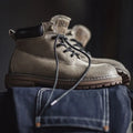 Brown leather boots with black laces on a dark background, Obroi