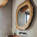 Wooden mirror with natural edge design on a wall, Obroi