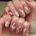 Close-up of hands with pink and gold nail art, Obroi