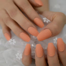 Close-up of hands with orange nail polish on a white fabric background ,Obroi