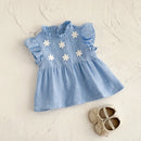 Blue dress with white floral patterns on a light beige background