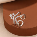 Silver ring with gemstones on a brown surface, Obroi