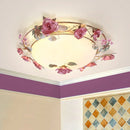 Ceiling light fixture with floral design on a wall with purple baseboard and tiled corner, Obroi
