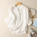 White blouse on a hanger with a handbag and shoes on a beige background, Obroi