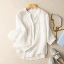 White blouse on a hanger with a handbag and shoes on a beige background, Obroi