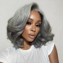 Woman with gray hair wearing a white top against a plain background, with 'Obroi' branding.