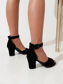 Black high-heeled shoes worn with sheer stockings on a white background, Obroi