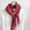 Pink scarf draped over a mannequin wearing a white shirt on a plain background, Obroi