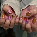 Close-up of hands with multicolored nail polish against a neutral background, Obroi