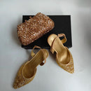 Gold embellished shoes and clutch on a white background, Obroi