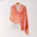 Coral pink scarf draped over a white top on a hanger against a white background, Obroi