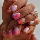 Close-up of a hand with gradient nail art on a neutral background, Obroi