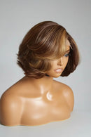 A short layered wig with medium brown and warm blonde highlights, displayed on a mannequin head against a plain light gray background, Obroi
