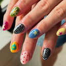 Colorful nail art on a hand with various designs, Obroi