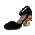 Black high-heeled shoe with floral design on a white background, Obroi
