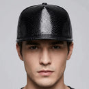 Man wearing a black textured baseball cap against a gray background, Obroi