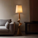 Modern floor lamp with a wooden base in a living room setting, Obroi