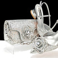 Silver glittery clutch and high-heeled shoes with floral designs on a white background, Obroi