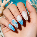Nails with blue and white ocean-themed design against a coral background, Obroi