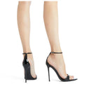 Black high-heeled shoes worn with sheer stockings on a white background, Obroi