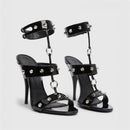 Black high-heeled sandals with studded details on a white background, featuring the Obroi brand.