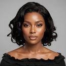 Woman with styled hair wearing a black off-shoulder top against a gray background, Obroi