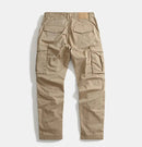 A pair of khaki cargo pants shown from the back, featuring a relaxed straight-leg fit, elastic waistband, and multiple utility cargo pockets, photographed against a light gray background, Obroi