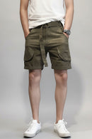 Person wearing olive green cargo shorts with a white background, Obroi