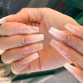 Close-up of hands with long, clear acrylic nails and rhinestone rings, Obroi