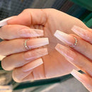 Close-up of hands with long, clear acrylic nails and rhinestone rings, Obroi