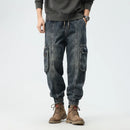 Person wearing blue cargo pants and brown boots on a light gray background