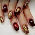 Nails with gold glitter and red nail art on a white background, Obroi
