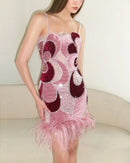 Woman wearing a pink and maroon dress with feather details on a white background, Obroi