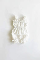 White baby romper with ruffled details on a light gray background, Obroi
