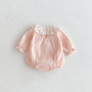 Pink baby romper with lace trim on a light gray background, Obroi