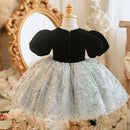 Black velvet top with a silver floral skirt on a mannequin against a decorative background, Obroi