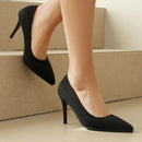 Black high-heeled shoes worn by a person on beige steps, Obroi