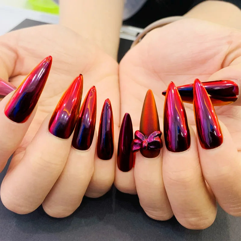 Obroi Nails with a gradient design of red and brown held by a person.