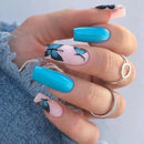Obroi Hand with turquoise nails and butterfly designs on a light background