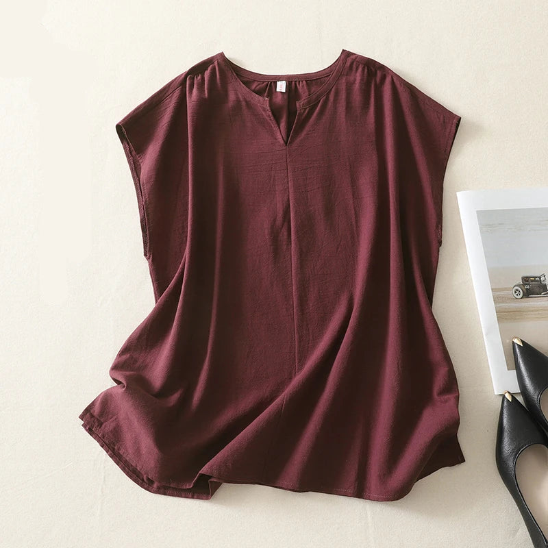 Maroon sleeveless top on a light beige surface with black high-heeled shoes and a white card in the background, Obroi