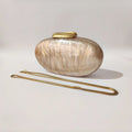 Oval-shaped handbag with a gold handle on a light gray background, Obroi