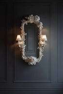 Decorative wall mirror with floral details on a dark paneled wall, Obroi