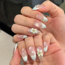 Close-up of hands with decorative nail art featuring flowers and white tips, Obroi