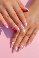 Close-up of hands with pink and white nail polish on a pink background, Obroi