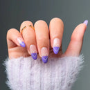 Hand with purple and white heart-shaped nail designs on a dark background, Obroi