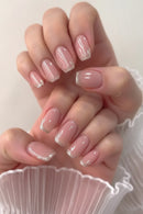 Close-up of a hand with pink nails and glittery accents on a white background, Obroi