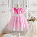 Pink princess dress on a mannequin against a decorative white wall, Obroi