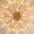 Decorative ceiling light fixture with gold branches and crystal-like elements on a beige background, Obroi