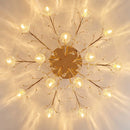 Decorative ceiling light fixture with gold branches and crystal-like elements on a beige background, Obroi