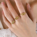 Gold floral rings on a hand with a soft background, Obroi